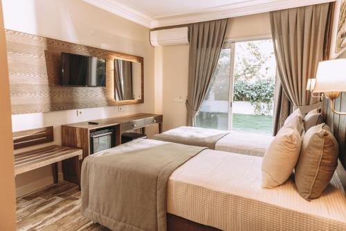 a hotel room with two beds and a window at Venezia Alaçatı in Yumru