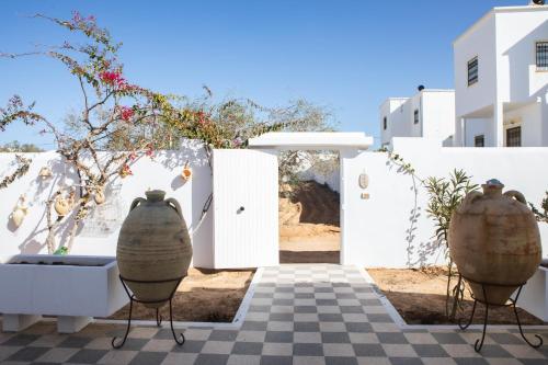 a view of a white building with two large vases at Villa Bianca - à 10 min de la plage in Fafou