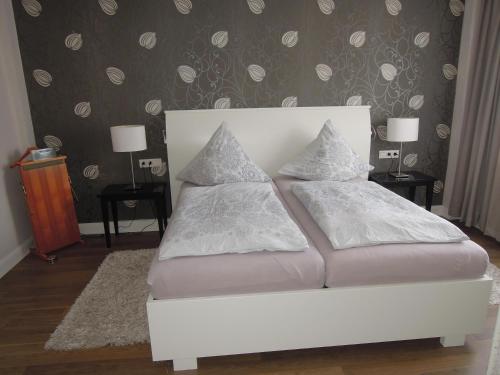 a white bed with pillows on it in a bedroom at Ferienwohnung Ein Zuhause auf Zeit in Lübeck