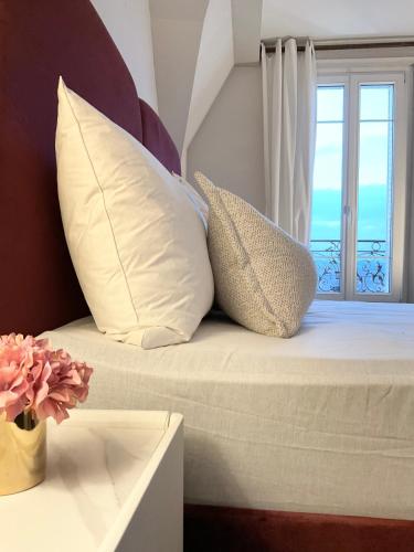 two pillows sitting on a bed with a window at RESIDENCE WAVES Paris Orly Aéroport in Villeneuve-Saint-Georges