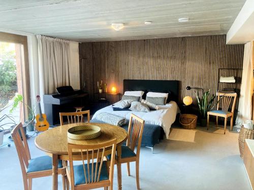 a bedroom with a bed and a table and a dining room at Sweet Valley Cozy in Zutendaal