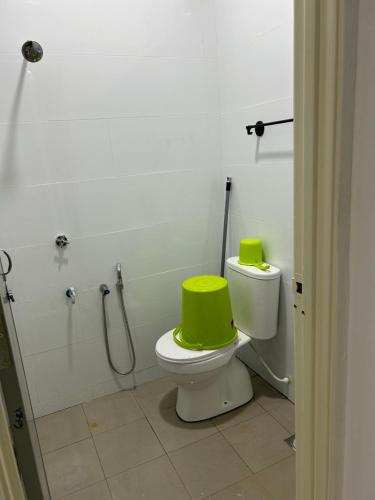 a bathroom with a toilet with a green seat at Ct Wani Homestay in Wakaf Baharu