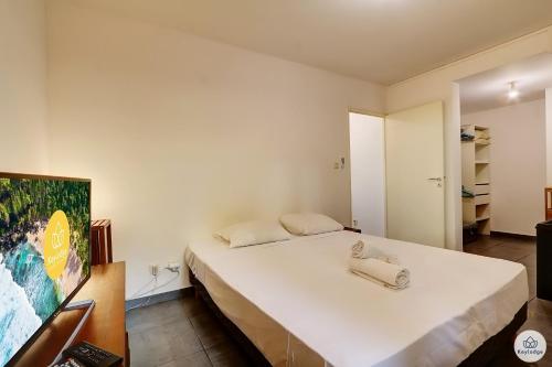 a bedroom with a white bed and a tv at Jardin Tropical 3 - 45 m2 - La Saline Les Bains in Saint-Paul