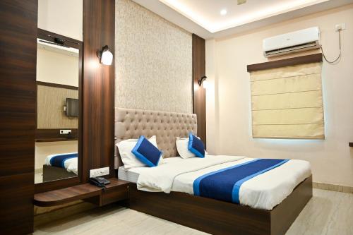 a hotel room with a bed and a mirror at Hotel Hari Gopal in Varanasi