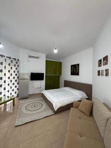 a bedroom with a bed and a couch and a television at Machiavelli Apartments Lura 1 in Draçi