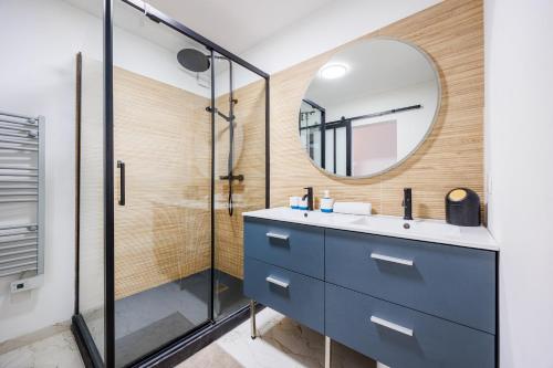 La salle de bains est pourvue d'une coiffeuse bleue et d'un miroir. dans l'établissement Osmoz En Vau - clim par Dodo à Cassis, à Cassis