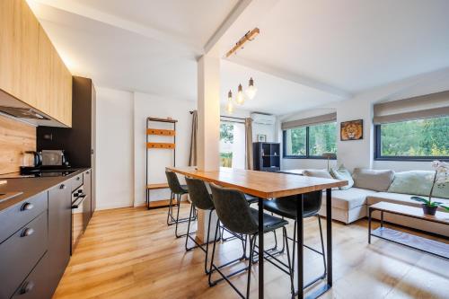 Il dispose d'une cuisine et d'un salon avec une table et des chaises en bois. dans l'établissement Osmoz En Vau - clim par Dodo à Cassis, à Cassis