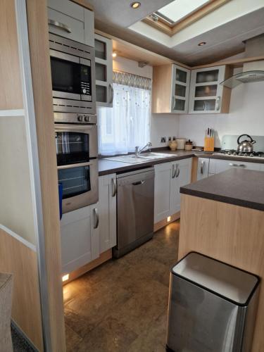 une cuisine avec des armoires blanches et des appareils en acier inoxydable dans l'établissement Lodge 1, à Rives