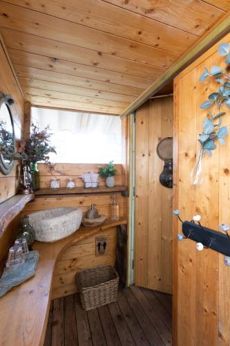 - une salle de bains dans une cabane en rondins avec lavabo dans l'établissement Cocoon Village, à Porto-Vecchio