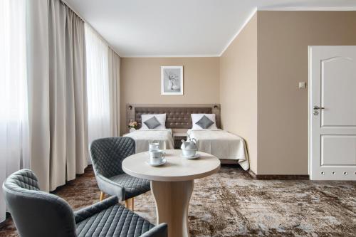a hotel room with a bed and a table and chairs at Hotel Mieszko in Gorzów Wielkopolski