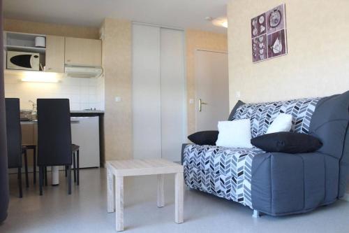 un salon avec un canapé bleu et une table dans l'établissement Appt Studio cabine LA ROCHELLE - LR040-105, à La Rochelle