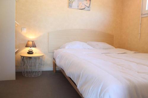 une chambre avec un grand lit blanc et une lampe dans l'établissement Appt Studio cabine LA ROCHELLE - LR040-105, à La Rochelle