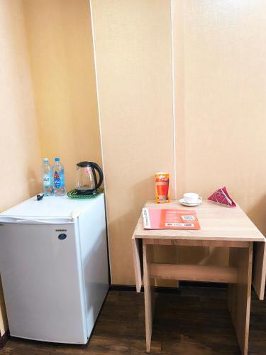 a small table next to a small refrigerator and a table at Гостиничный комплекс Алтай in Lenīnogorsk
