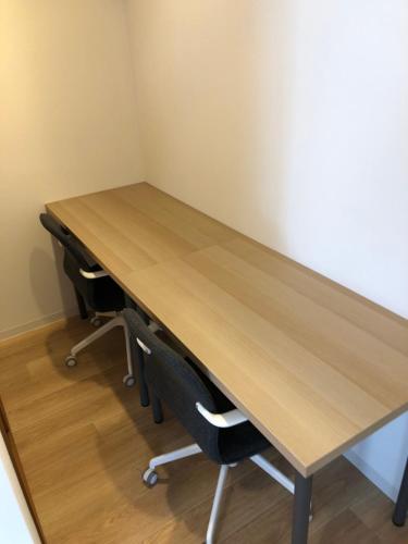 a wooden table with two chairs in a room at グランディオーソ中野富士見町 in Tokyo