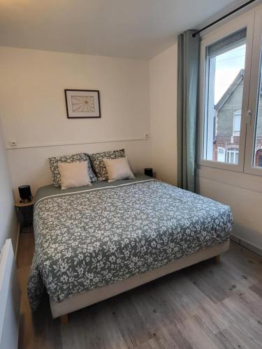 une chambre avec un grand lit et une fenêtre dans l'établissement Le Fassio - Wifi - Stationnement gratuit, à Lens