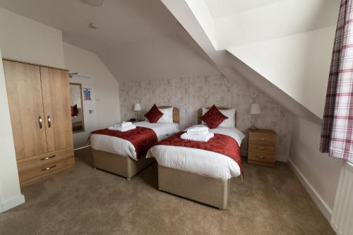 a bedroom with two beds with red and white sheets at The Lakeland Kendal Hotel, Sure Hotel Collection by Best Western in Kendal
