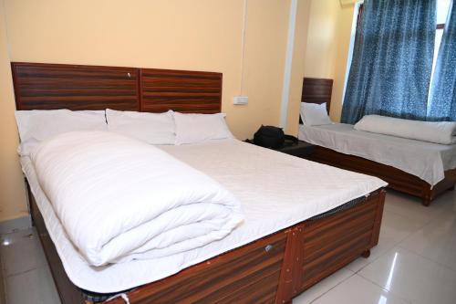 a bedroom with two beds with white sheets at RK Residency Ukhimath in Ukhimath
