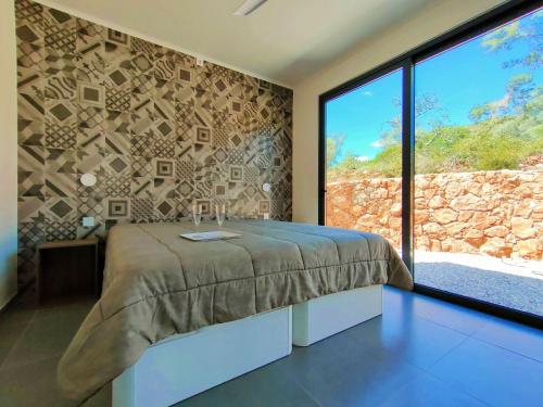 a bedroom with a bed and a large window at Casa-Diospiro-villa-for-4P-baby-with-private-pool in São Bartolomeu de Messines