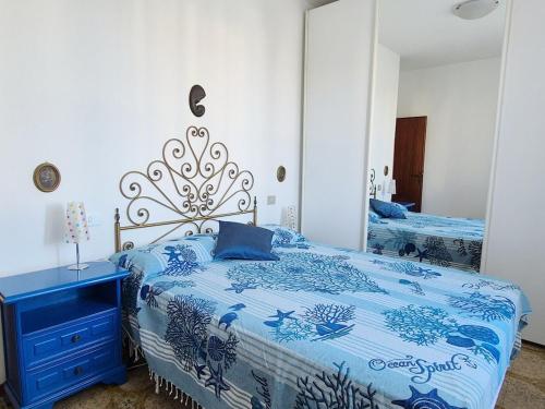 a bedroom with a blue and white bed and a mirror at Casa Naldina in Marciana Marina