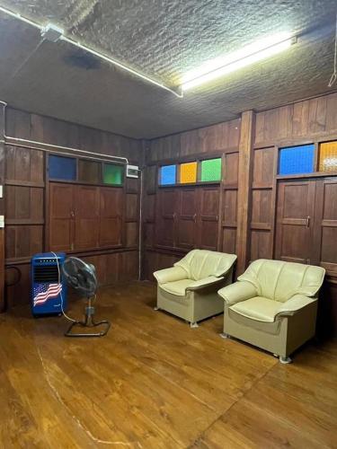 a room with two chairs and a fan in it at Thai Wooden Garden House By Paddy Fields Haven - Natures Nest in Pai