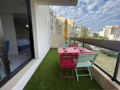 une table et des chaises roses sur le balcon d'une maison dans l'établissement Appt 2 pièces LA ROCHELLE - LR090-D212, à La Rochelle