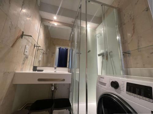 une salle de bain avec douche et lavabo et une machine à laver dans l'établissement Appt 2 pièces LA ROCHELLE - LR090-D212, à La Rochelle