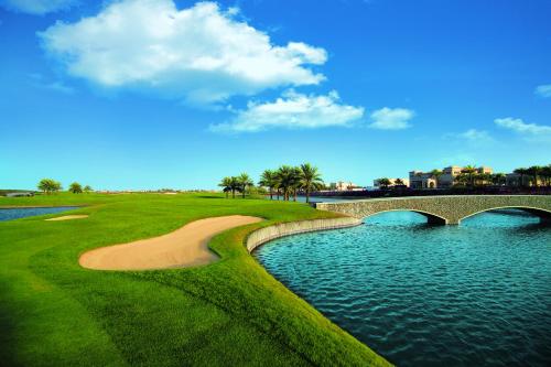 a bridge over a river next to a golf course at Arabian Ranches Golf Club in Dubai