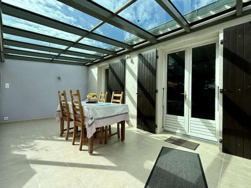une véranda avec une table et des chaises sur une terrasse dans l'établissement Mais 3 pièces 4 couchages SAINT GEORGES D'OLERON SGO000-102, à Saint-Georges-dʼOléron