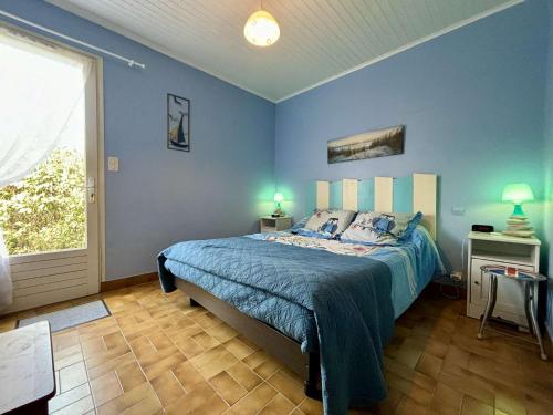une chambre bleue avec un lit et une fenêtre dans l'établissement Mais 3 pièces 4 couchages SAINT GEORGES D'OLERON SGO000-102, à Saint-Georges-dʼOléron