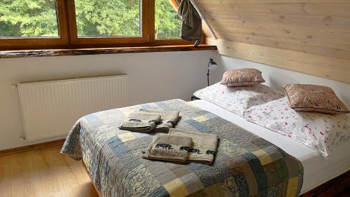 a bedroom with a bed with a blanket and pillows at Sasek Mały # Pensjonat # Jazdy Konne in Szczytno