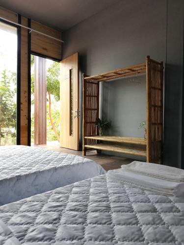 a bedroom with a large bed and a large window at Khu nghỉ dưỡng sinh thái Apsara Sóc Trăng in Ấp Vĩnh Hưng