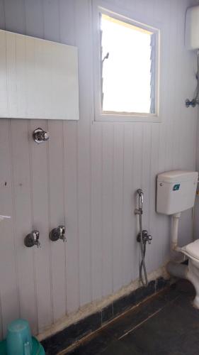 a bathroom with a toilet and a window at Sky Lawns in Lonavala