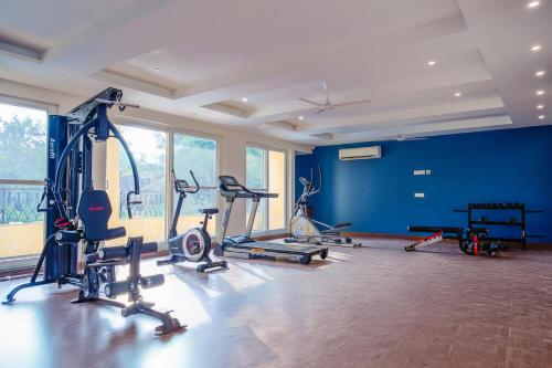 a gym with several exercise equipment in a room with blue walls at Alaya Stays 1 BHK with Balcony & Pool - Veera Marina in Goa