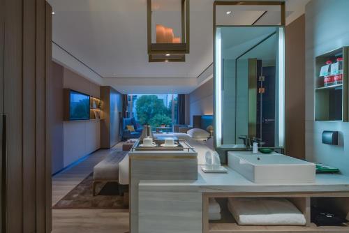 a bathroom with a sink and a large mirror at Lijiang Old Town Echarm Plus Hotel in Lijiang