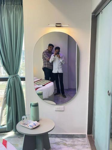 a man taking a picture of himself in a mirror at Hotel Melbourne in Gandhinagar