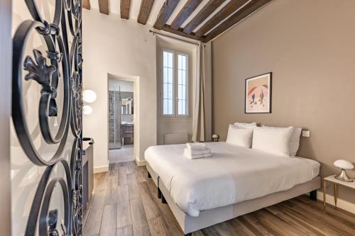 une chambre avec un lit blanc et un parquet dans l'établissement Charming Apartment 2BR 6P St-Germain-des-prés, à Paris