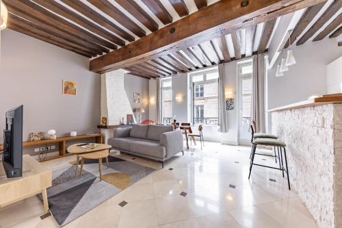 un salon avec un canapé et une télévision dans l'établissement Charming Apartment 2BR 6P St-Germain-des-prés, à Paris