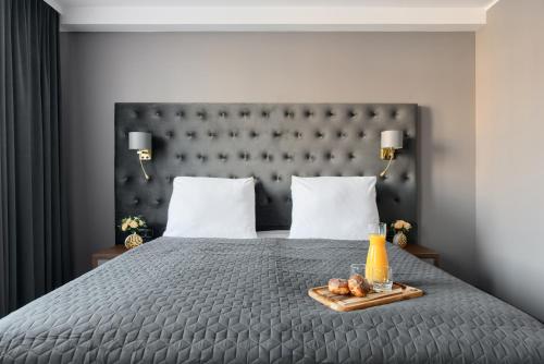 a bed with a tray of food and a bottle of orange juice at Hotel Mieszko in Gorzów Wielkopolski