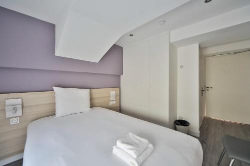 a bedroom with a large white bed with purple walls at 10 Studio Charenton Chambre Fitness Cinema in Charenton-le-Pont