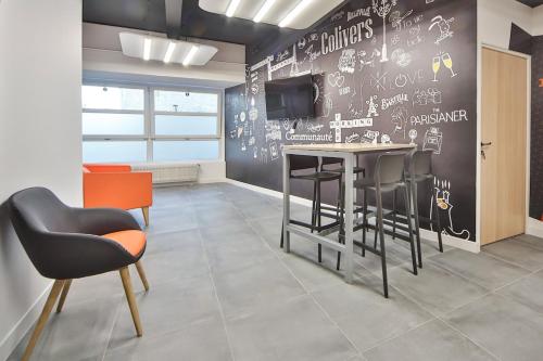 a room with a table and chairs and a wall with graffiti at 10 Studio Charenton Chambre Fitness Cinema in Charenton-le-Pont