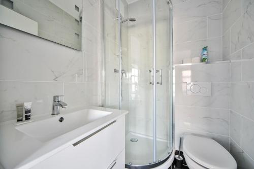 a white bathroom with a shower and a toilet at 10 Studio Charenton Chambre Fitness Cinema in Charenton-le-Pont