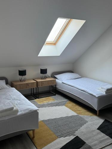 a attic bedroom with two beds and a skylight at Nostalgia restaurant & pension in Rimavská Sobota