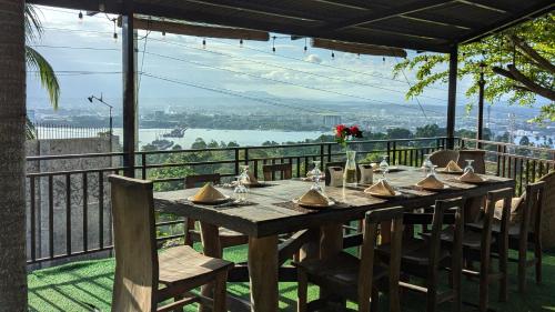 a wooden table with chairs and a view of a river at Castle View Hotel Samal in Magamomo
