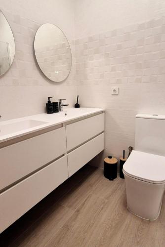 a bathroom with a sink and a toilet and a mirror at Green Oasis in Gran Alacant