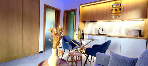 a kitchen with a table and some blue chairs at Aquarius Porto Boszkowo Apartamenty in Boszkowo