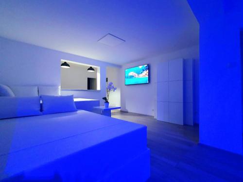niebieski pokój z łóżkiem i telewizorem w obiekcie Jacuzzi and Pool Apartments w mieście Matulji
