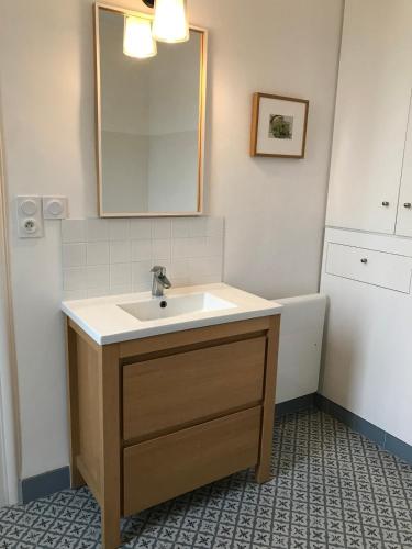 une salle de bain avec un lavabo et un miroir dans l'établissement House Île Grande, à Pleumeur-Bodou