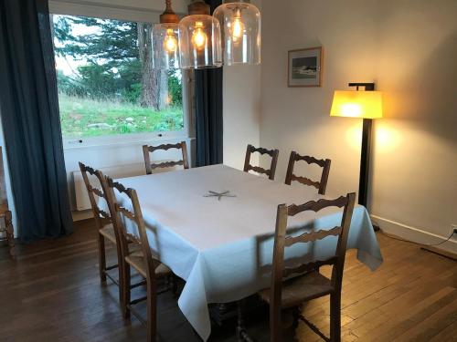 d'une table à manger, de chaises, d'une table et d'une fenêtre. dans l'établissement House Île Grande, à Pleumeur-Bodou