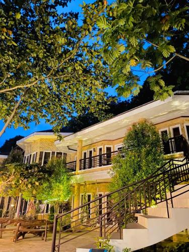 a large yellow building with a staircase in front of it at Castle View Hotel Samal in Magamomo