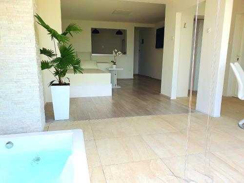 łazienka z wanną i rośliną w pokoju w obiekcie Jacuzzi and Pool Apartments w mieście Matulji